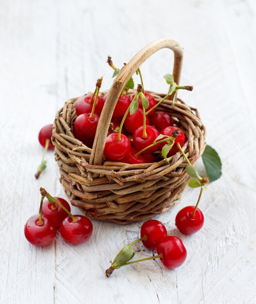 Cerises aigres fraîches dans un panier sur une table en bois