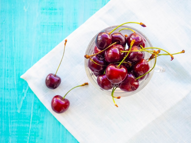 Cerises. Cerise. Cerises dans un bol de couleur et une serviette de cuisine.