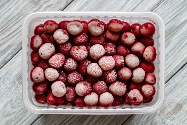 Cerises congelées avec givre dans une boîte en plastique