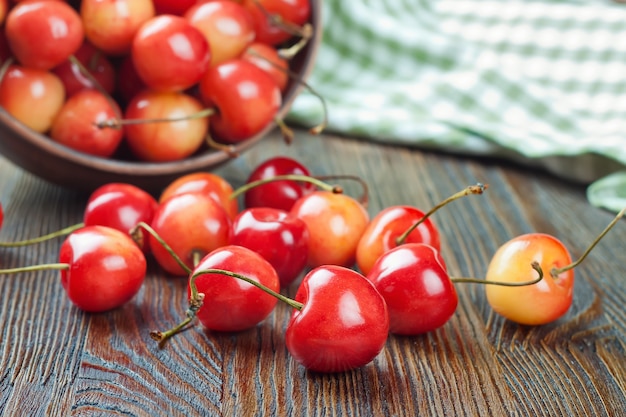 Cerises dans le bol sur un fond de bois brun.