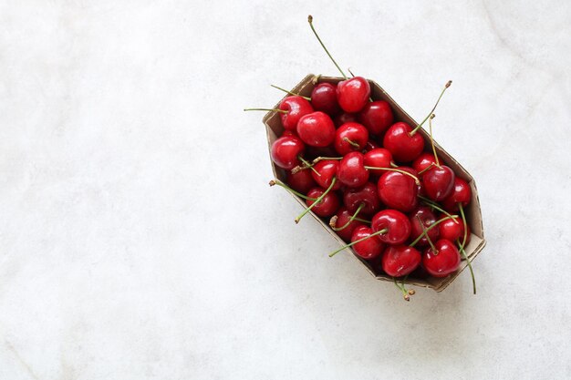 Cerises dans une vue de dessus de plateau en carton