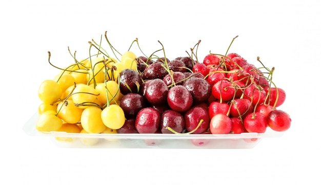 Cerises de différentes sortes et couleurs avec des gouttes d'eau. Aliments sains isolés