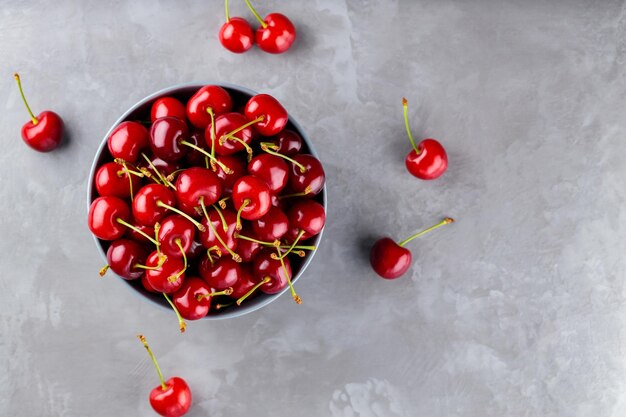 Des cerises douces dans un bol Des cerises mûres sur un fond gris Des baies de cerises fraîchement cueillies sur du béton