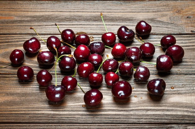 Cerises douces juteuses mûres sur un fond en bois Cerises fraîches humides avec des gouttes d'eau