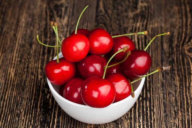 Cerises douces mûres rouges sur une table en bois, cerises rouges mûres de grande taille