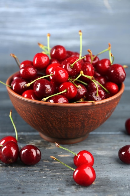 Cerises fraîches dans un bol sur fond de bois