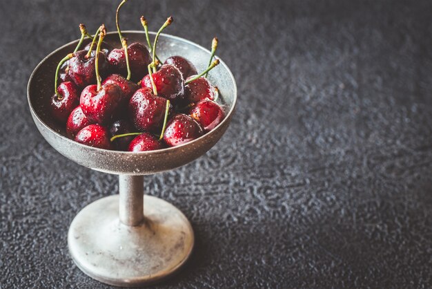 Cerises fraîches dans un vase en argent vintage