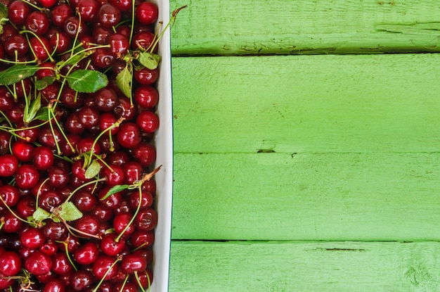 Cerises fraîches juteuses sur un fond en bois clair