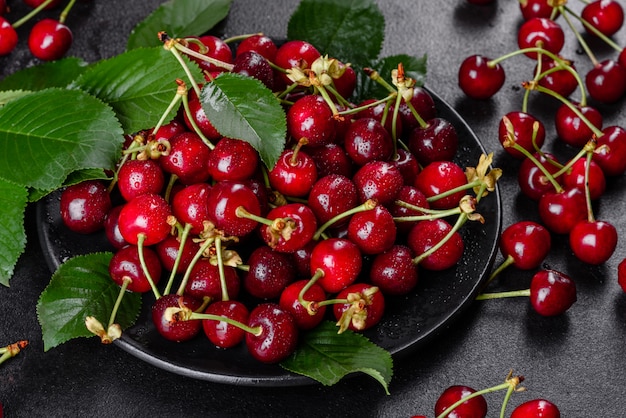 Cerises fraîches et juteuses sur une plaque noire