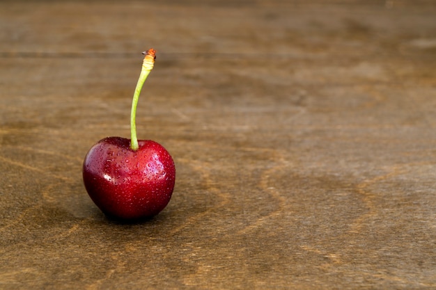 Cerises fraîches mûres sur fond en bois.