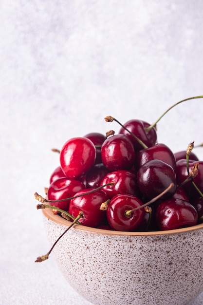 Cerises en gros plan de tasse beige ronde