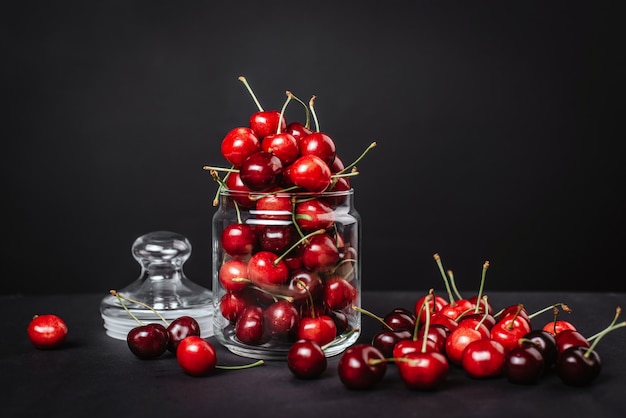 Cerises juteuses mûres dans un verre sur dark