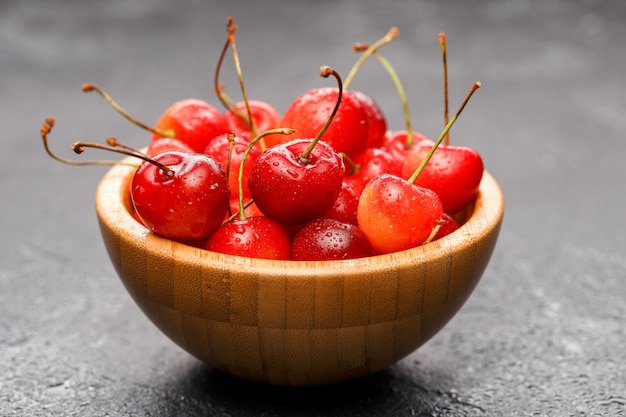 Cerises mûres dans un bol en bois