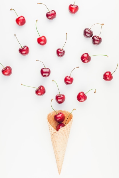 Cerises mûres dans un cône de gaufre isolé