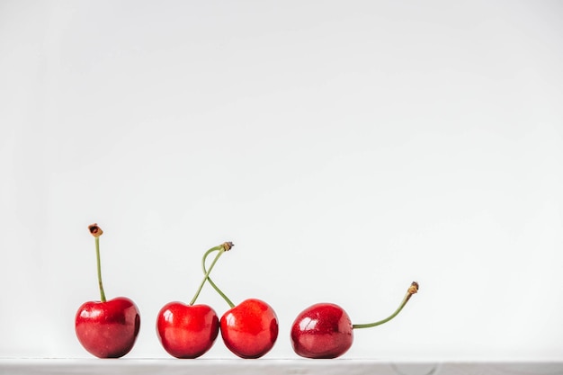 Cerises mûres fraîches sur le fond en bois blanc Copiez l'espace vide pour le texte