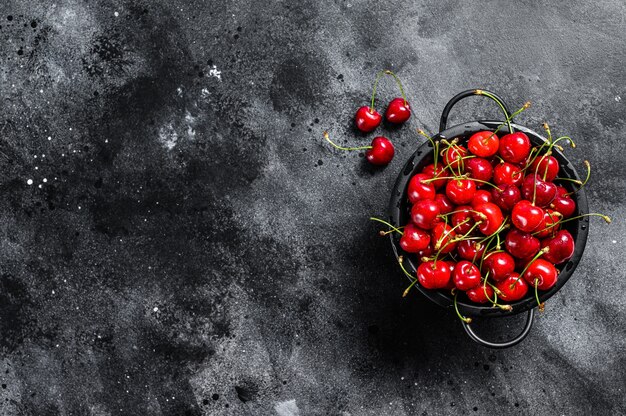 Cerises mûres rouges dans une passoire