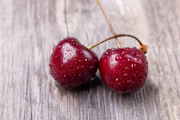 Cerises noires mûres fraîches sur un bois gris