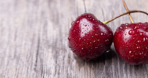 Cerises noires mûres fraîches sur un bois gris