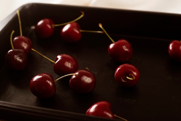 Cerises à plat éparpillées sur une plaque à pâtisserie