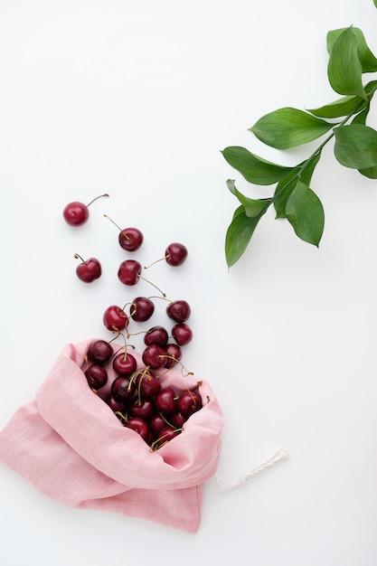 Cerises rouges fraîches et mûres biologiques renversées du sac