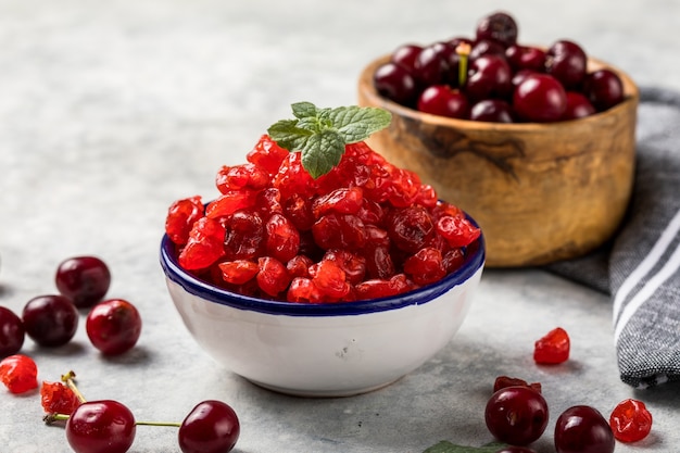 Cerises séchées avec des baies fraîches sur une surface blanche