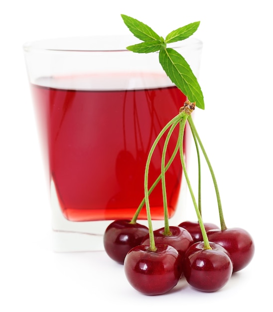 Cerises et un verre de jus de cerise isolé sur blanc