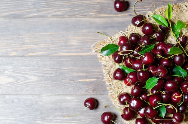 Cerises sur le vieux tissu. Récolte fraîche. Style rustique.