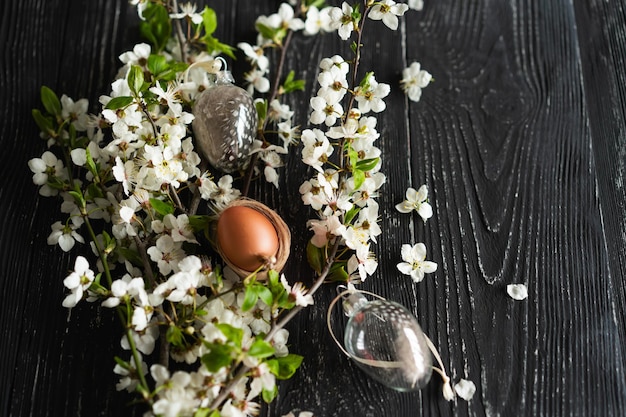 Des cerisiers en fleurs de printemps et des œufs de Pâques sur un vieux fond en bois