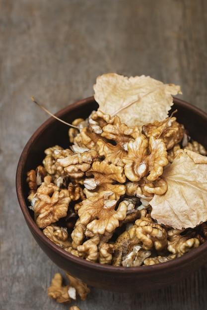 Cerneaux de noix dans un bol en argile sur table en bois