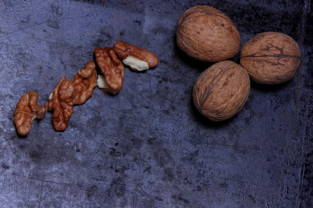 Cerneaux de noix et noix entières sur fond sombre Concept de cuisine végétarienne Vue rapprochée d'en haut