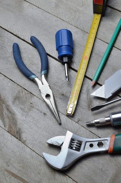 Certains outils de réparation à domicile se trouvent sur un fond en bois. fermer.