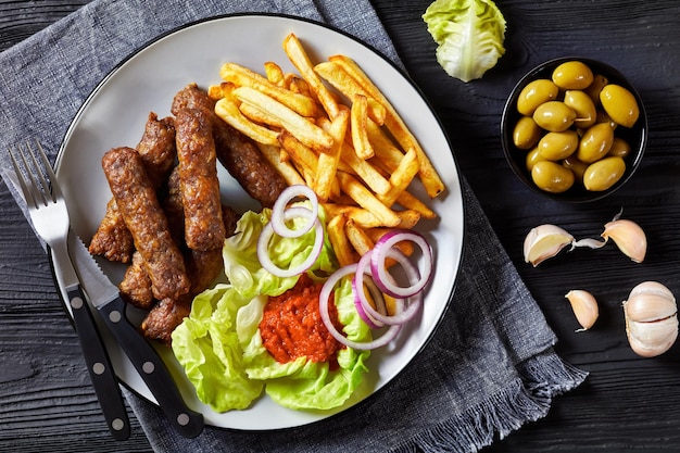 Cevapcici avec frites de pommes de terre laitue oignon ajvar