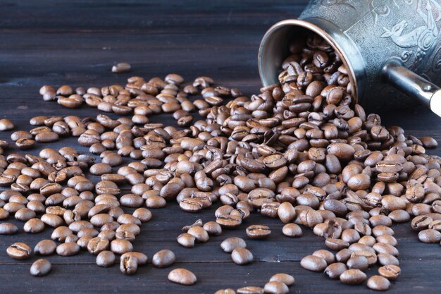 Cezve avec des grains de café fraîchement torréfiés sur un sac