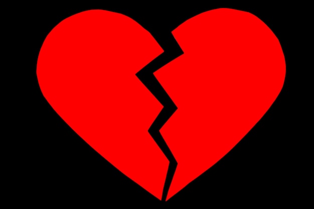 Photo chagrin rouge / cœur brisé. gros plan d'un coeur brisé en papier sur fond noir avec un tracé de détourage