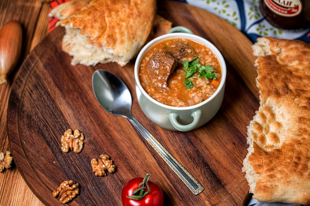 Chahokhbili entouré de légumes sur une table en bois