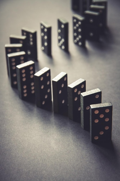 Chaîne de dominos noirs sur fond de table