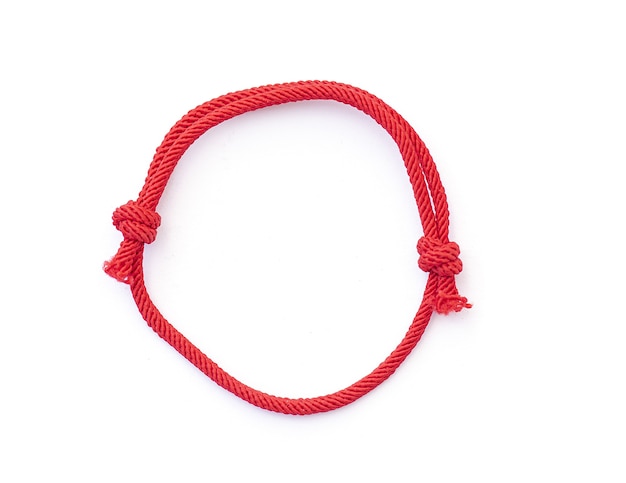 Chaîne de fil rouge comme amilet pour poignet isolé sur blanc Braslet rouge avec noeuds Vue de dessus