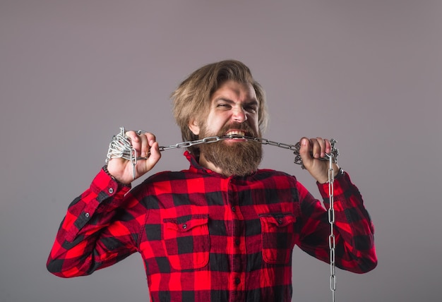 Chaîne en métal. Dépendance. Notion de liberté. Homme avec chaîne en métal. Homme barbu avec chaîne. Trimer. Problèmes de personnes. Éclater.