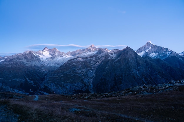 Photo une chaîne de montagnes avec un ciel bleu sur les alpes suisses à l'aube