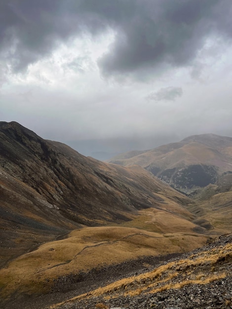 Une chaîne de montagnes avec un ciel nuageux en arrière-plan