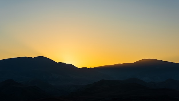 Chaîne de montagnes qui se profile après le coucher du soleil