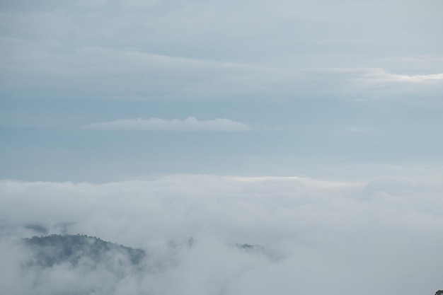 Chaîne de montagnes avec des silhouettes visibles à travers le brouillard bleu du matin