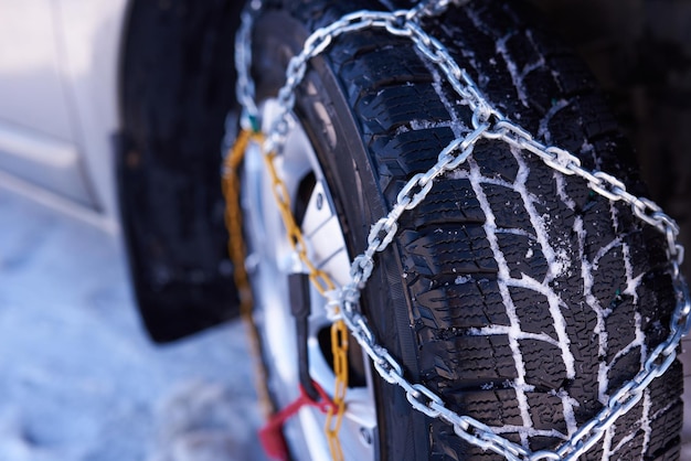 Chaîne à neige sur une roue dans la neige profonde en hiver