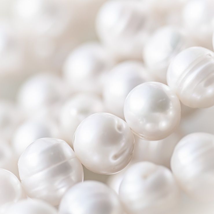 Photo chaîne de perles blanches nature en flou avec des reflets