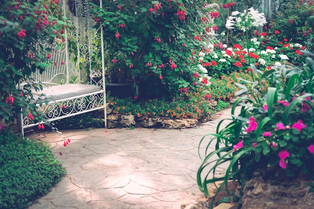 Chaise assise en métal blanc dans le parc de jardin fleuri au printemps été