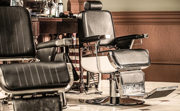 Chaise de barbier vintage élégante Coiffeur professionnel à l'intérieur du salon de coiffure Chaise de salon de coiffure Fauteuil de salon de coiffure Coiffeur moderne et salon de coiffure Salon de coiffure pour hommes Barbe homme barbu