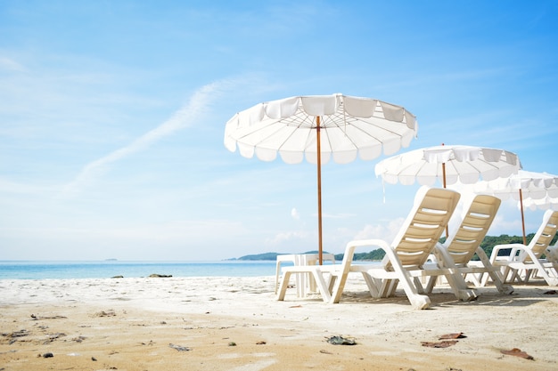 Chaise blanche avec parasol sur la plage en bord de mer