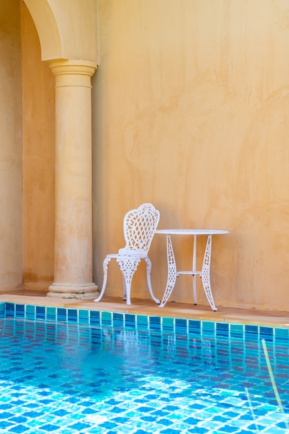 Chaise Blanche Vide Et Table Sur Le Côté De La Piscine