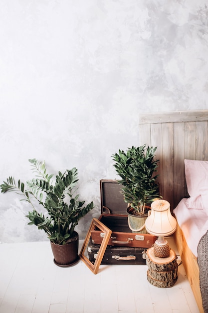 Chaise en bois à la coiffeuse à l'intérieur de la chambre pastel rose avec lampe dorée à côté du lit