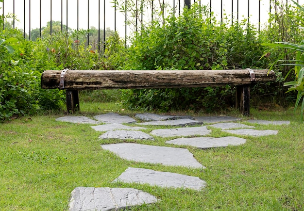 Chaise en bois d'extérieur dans le jardin avec motif en pierre à pied